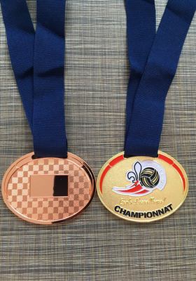 Médaille ovale dorée à émail de couleur pour un championnat de volleyball, montrée avec son revers bronze à motif damier