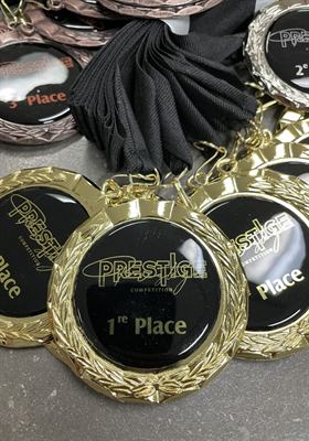 Gros plan sur une médaille dorée à couronne de laurier et centre noir laqué gravé première place