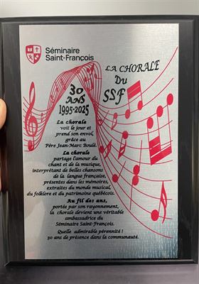 Plaque d’aluminium gravée de portées et de notes de musique rouges soulignant les trente ans d’une chorale