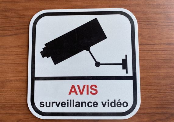 Panneau réfléchissant à pictogramme de caméra et mention bilingue d’avis de surveillance