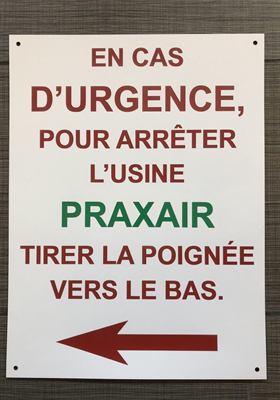 Panneau d’urgence industrielle indiquant la marche à suivre pour arrêter une usine, avec flèche directionnelle