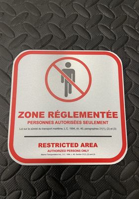 Panneau réfléchissant bilingue « Zone réglementée — personnes autorisées seulement », citant la loi sur la sûreté du transport maritime
