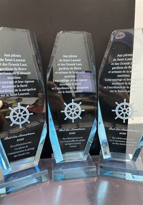 Trois trophées de cristal à base bleue gravés d’une roue de gouvernail et d’un texte d’hommage aux pilotes du Saint-Laurent