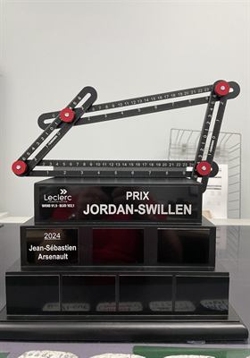 Trophée perpétuel composé d’une règle articulée montée sur un socle noir à étages garni de plaquettes